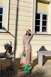 a lady wears a beige asymmetrical top and tulle midi skirt